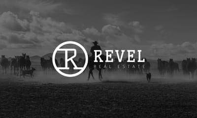 Revel Real Estate logo over a misty field